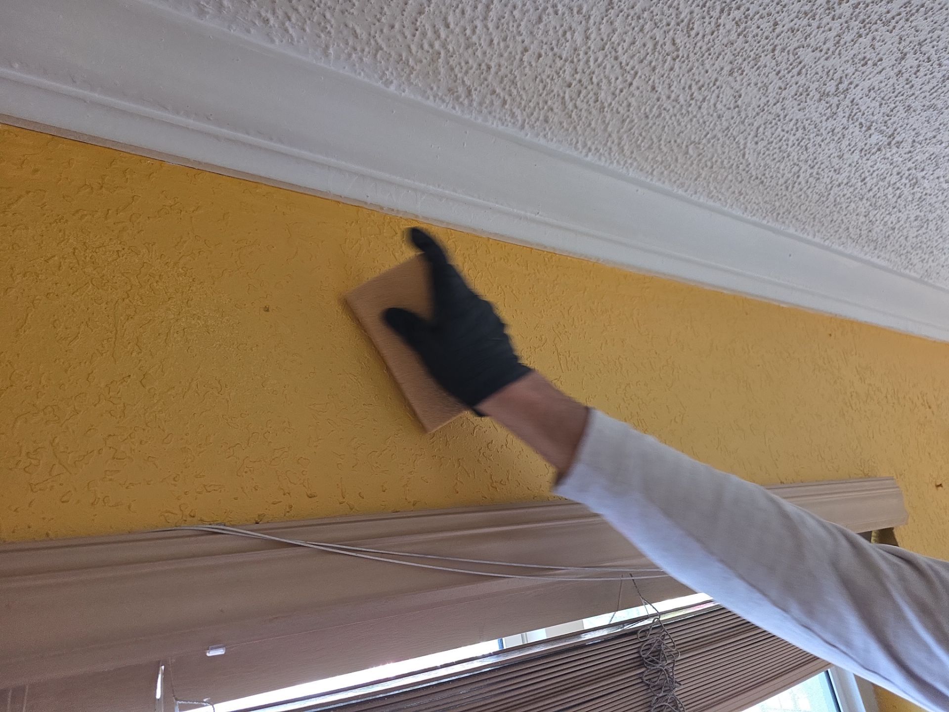 Technician cleaning soot and smoke damage from textured wall surface
